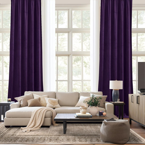 Rich plum velvet drapes with gathered top hang elegantly, framing a large living room window.
