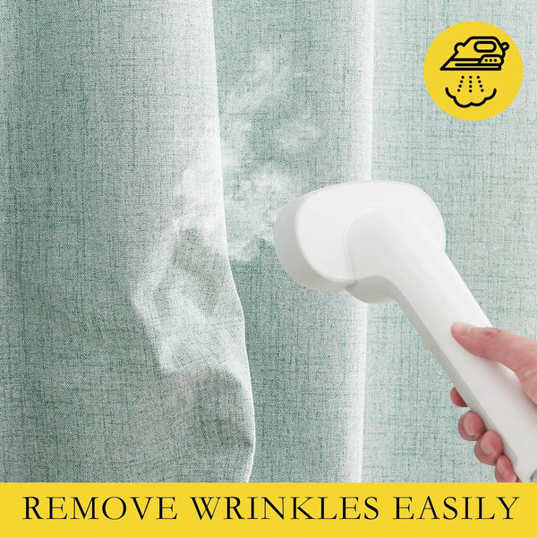 Hand using a white portable garment steamer to remove wrinkles from light green woven fabric.