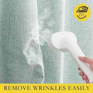 Hand using a white portable garment steamer to remove wrinkles from light green woven fabric.