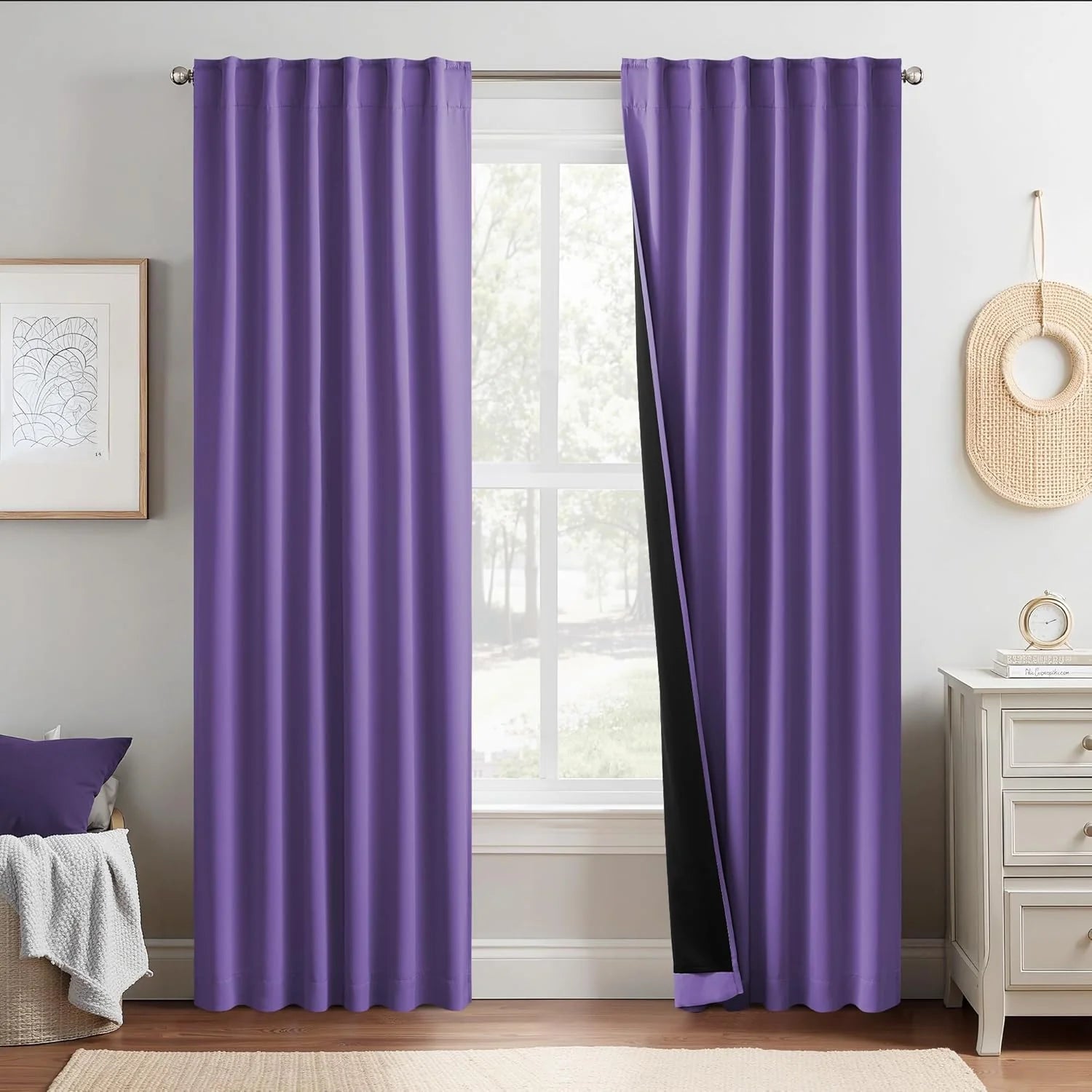 Purple blackout curtains with black lining hanging over a bedroom window
