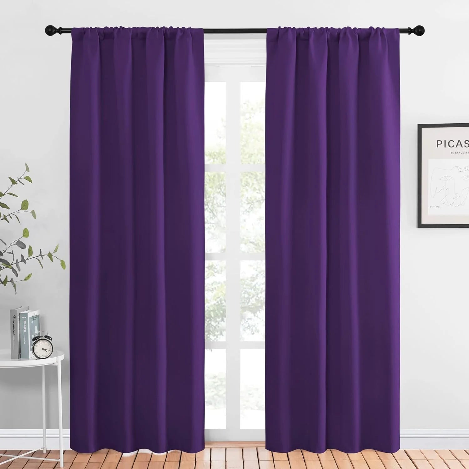 Purple blackout curtains hanging on a black rod in a bright modern room