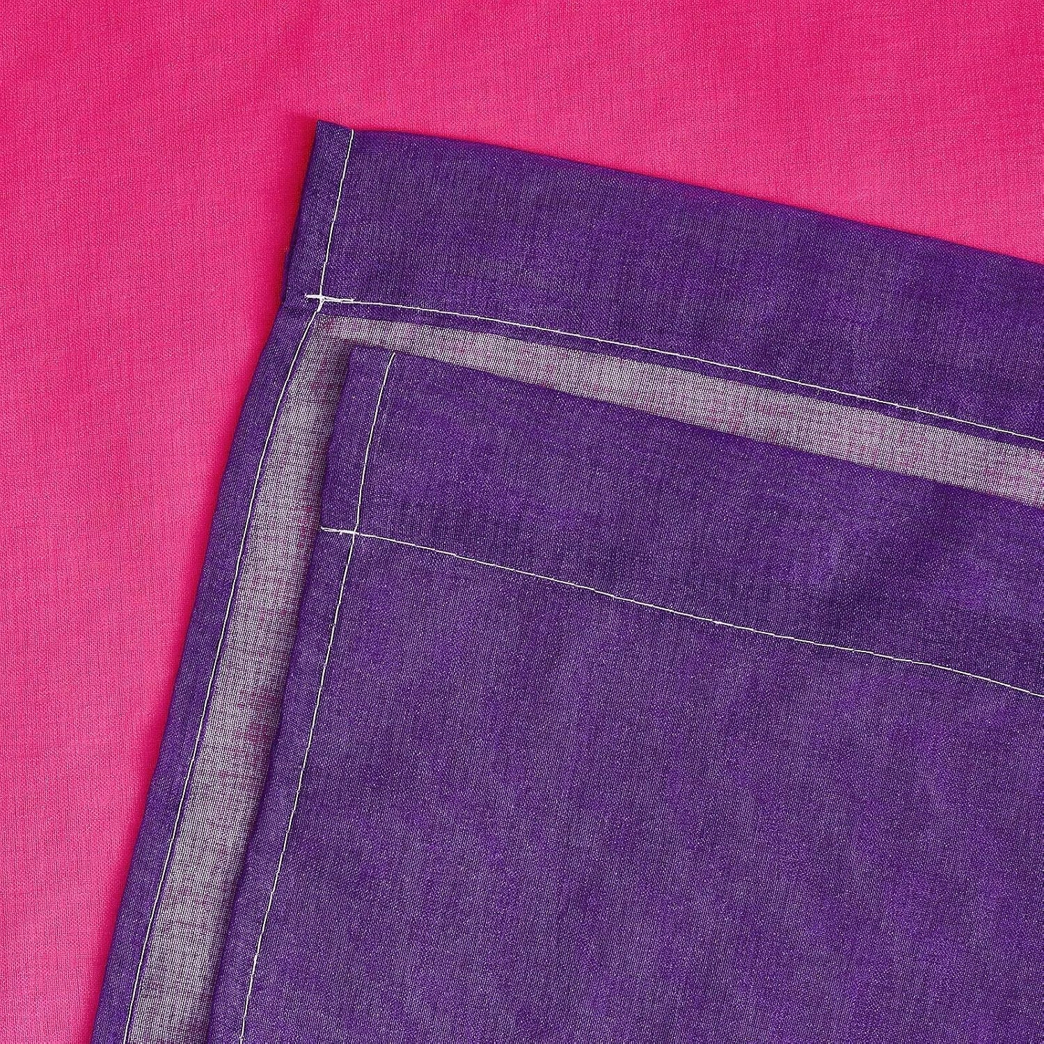 Close-up of purple fabric with stitched hem and folded edge on pink background