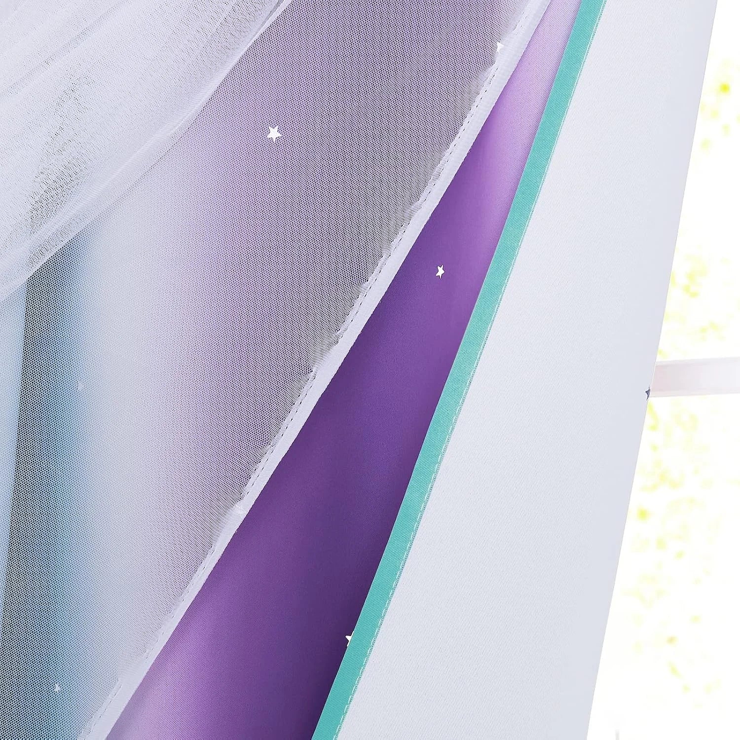 White sheer overlay on purple kids blackout curtain with star cutouts and aqua trim