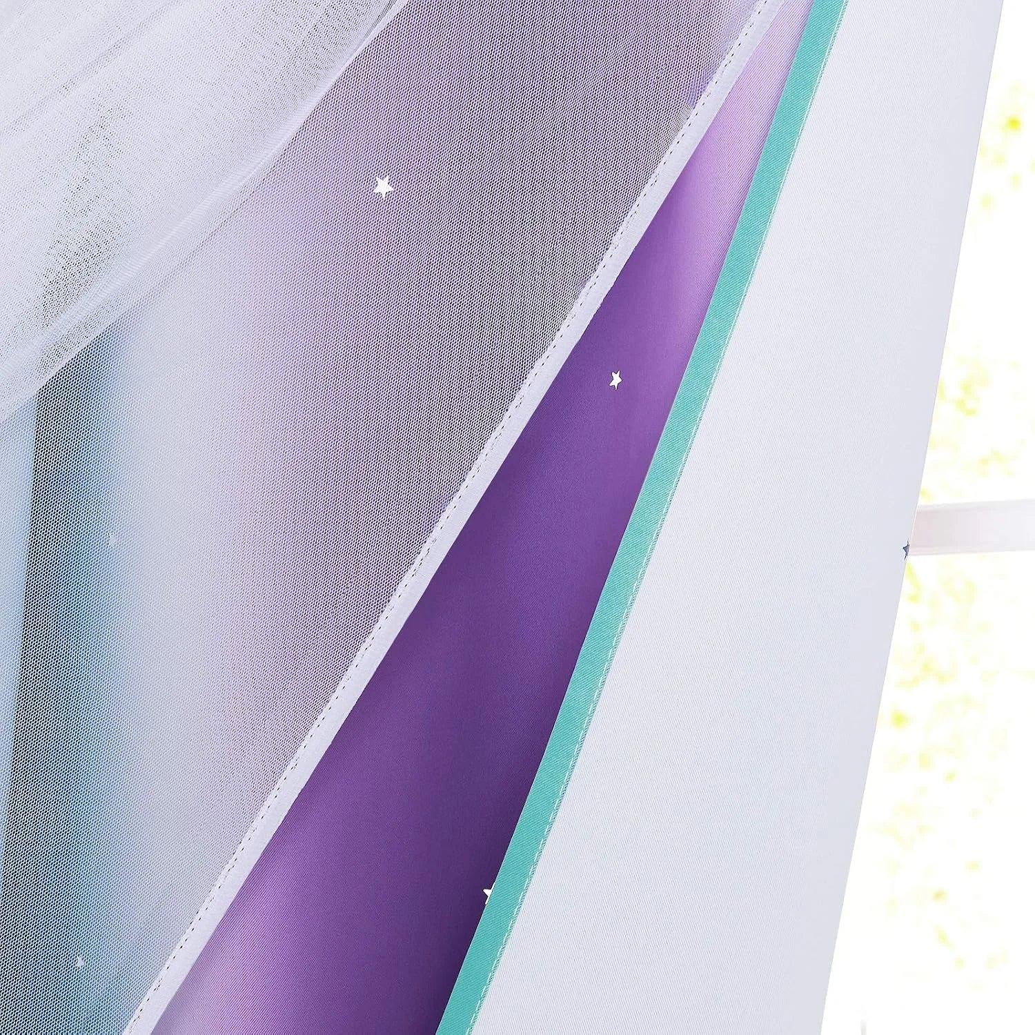 Layered white sheer and purple blackout curtains with star details and aqua trim