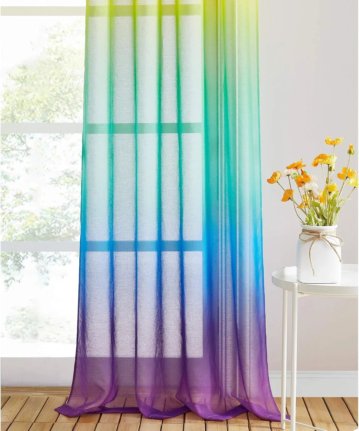 Rainbow ombre sheer curtain panel in green, blue, and purple by a bright window