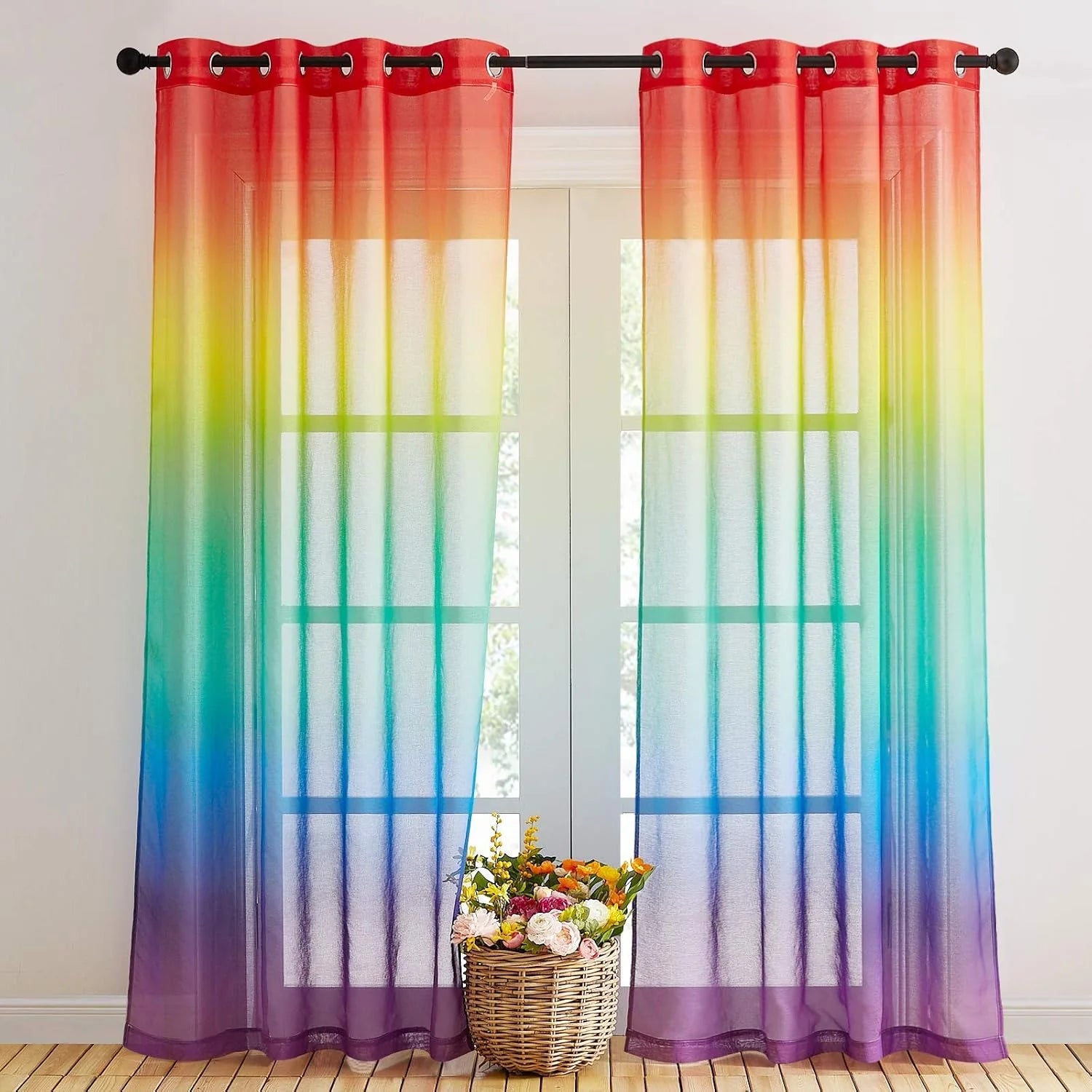 Rainbow ombre sheer curtains with grommet top hanging over a bright window