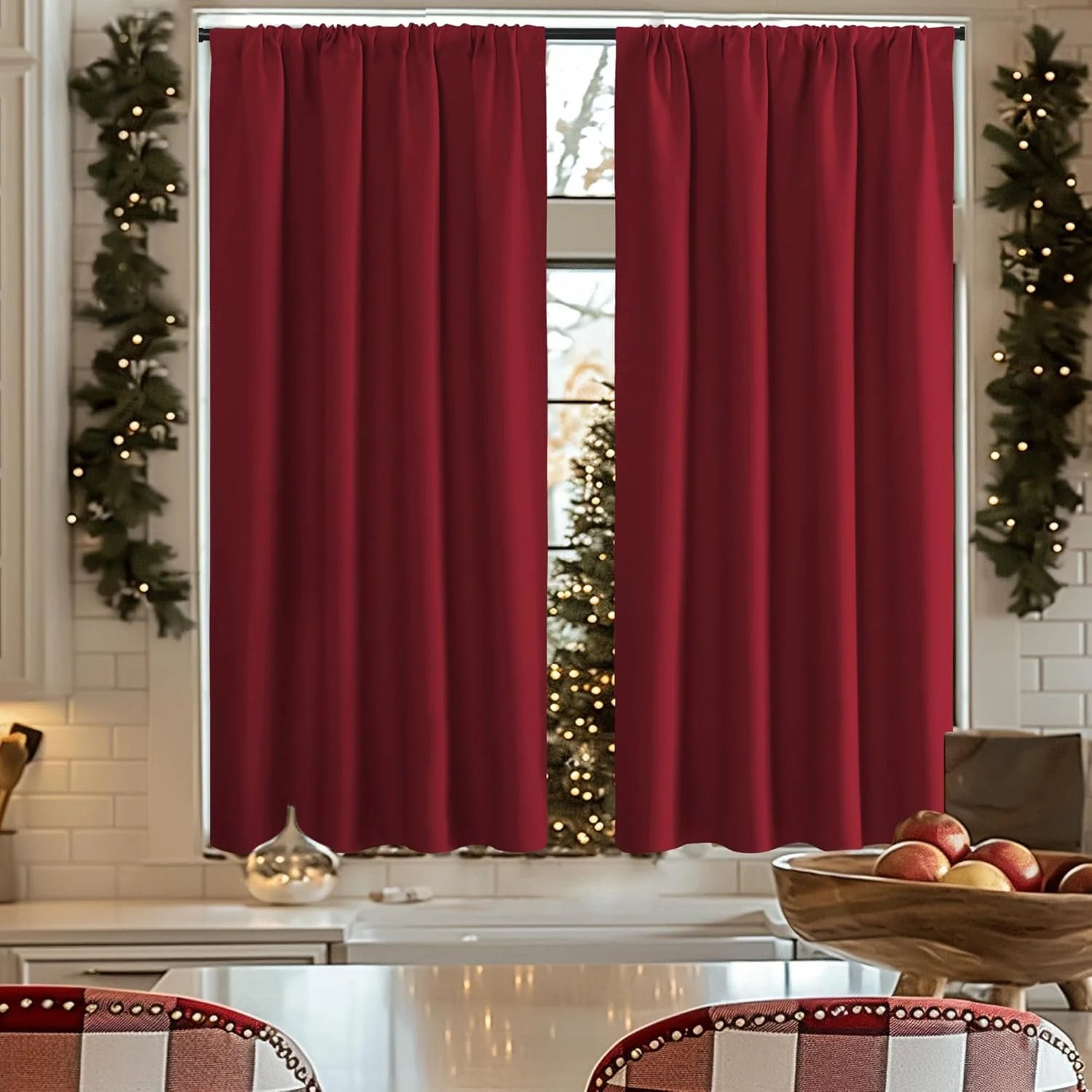 Deep red blackout curtains hanging over a kitchen window with festive holiday decor