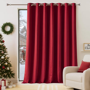 Deep red grommet blackout curtain panel on a silver rod, in a room with a christmas tree.
