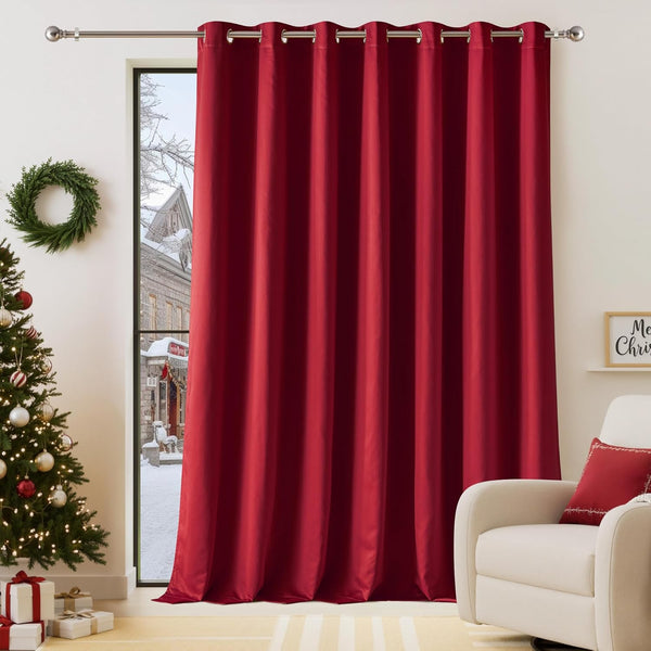 Deep red grommet blackout curtain panel on a silver rod, in a room with a christmas tree.