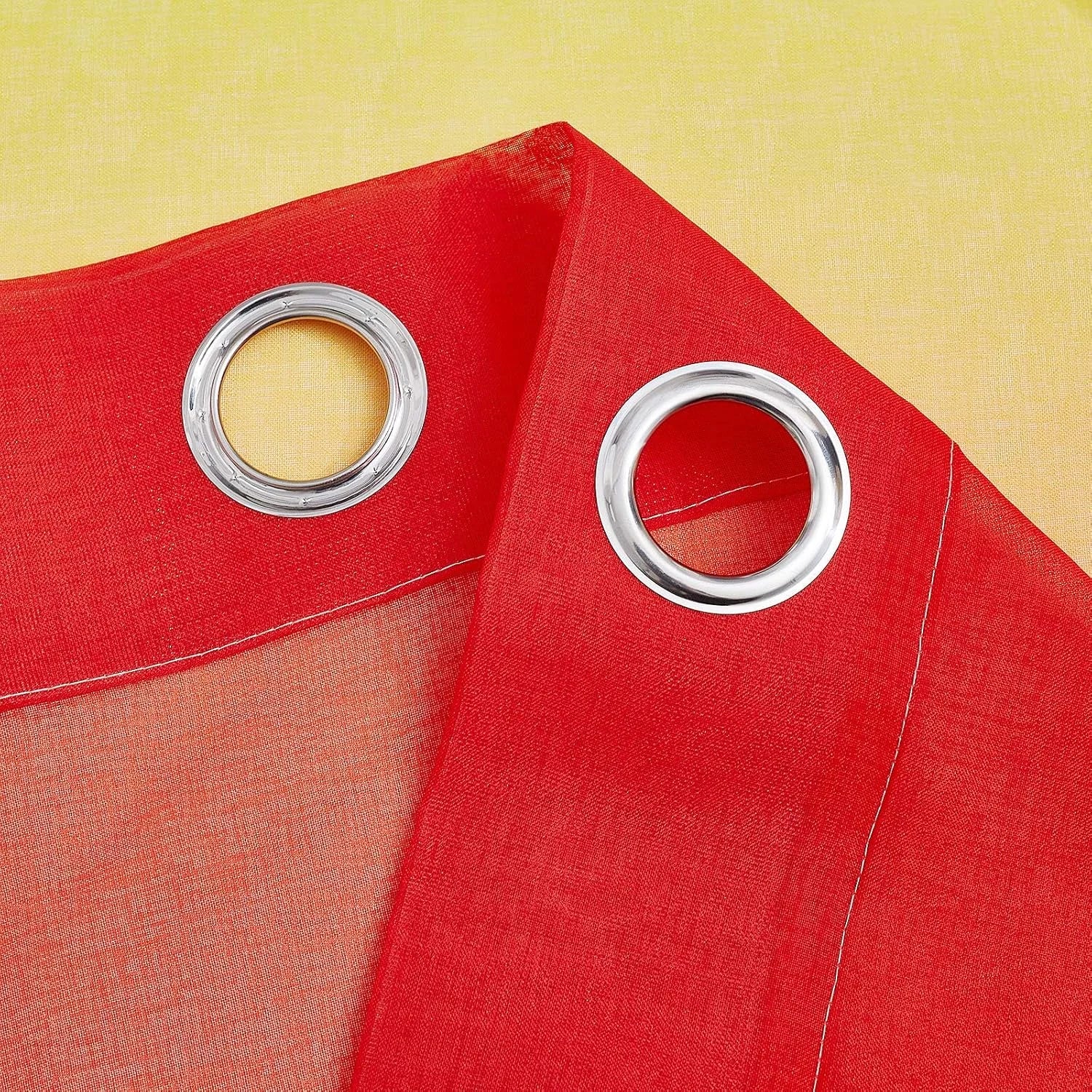 Red sheer curtain panel with silver metal grommets and stitched header detail