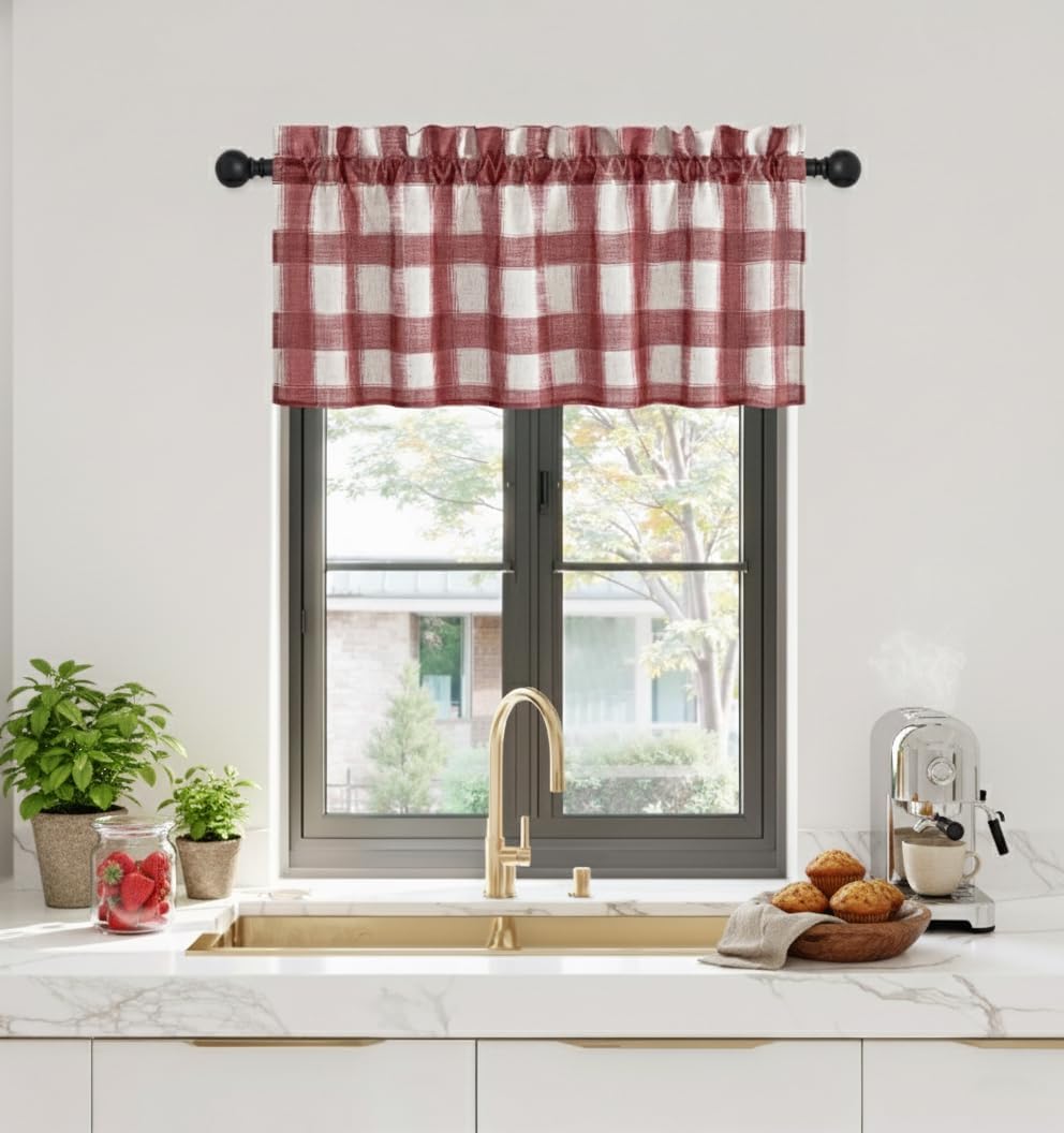 Red and white gingham check valance with gathered top hanging over a kitchen window with gold faucet.