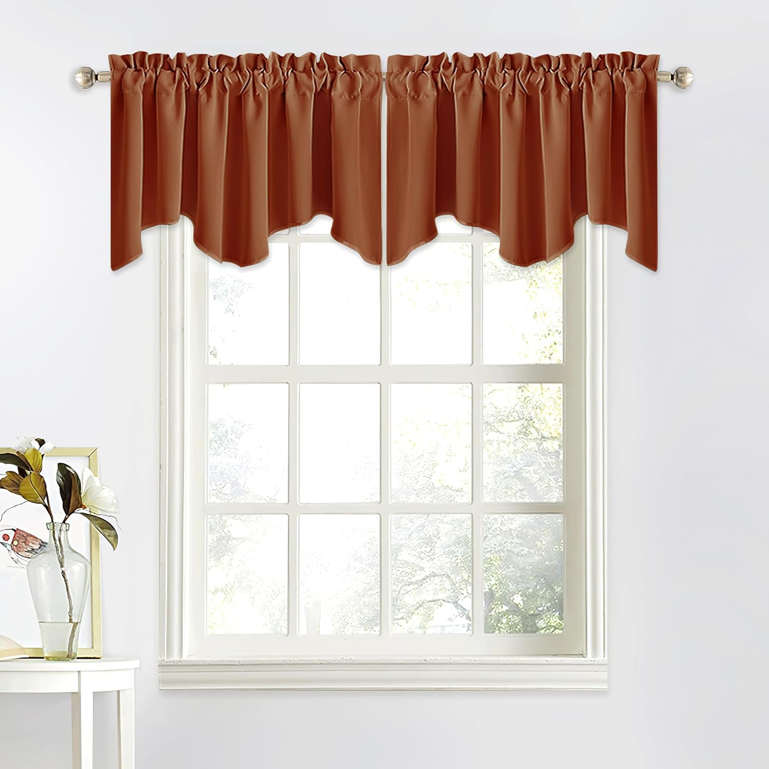Rust brown gathered window valance with a scalloped hem, hung on a silver rod above a white-framed window.