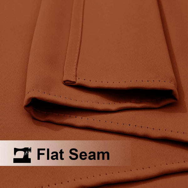 Close-up of rust-colored smooth fabric with precise, durable flat seam stitching.
