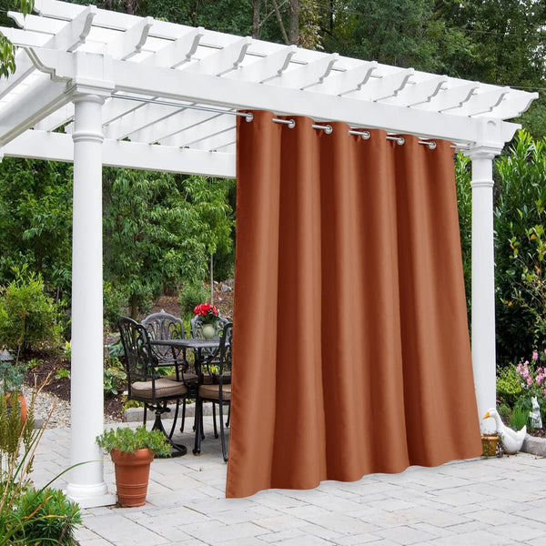 Rust orange outdoor grommet curtain hanging from white pergola, shading patio dining set.