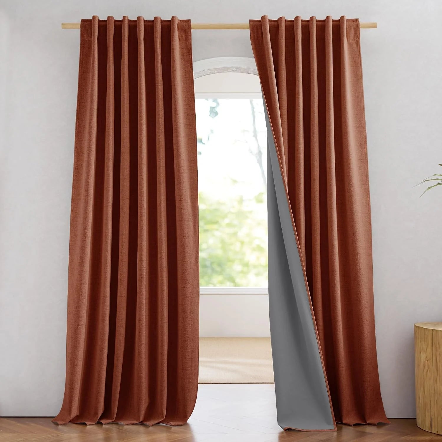 Rust brown thermal blackout curtains with pleated header on a wooden rod
