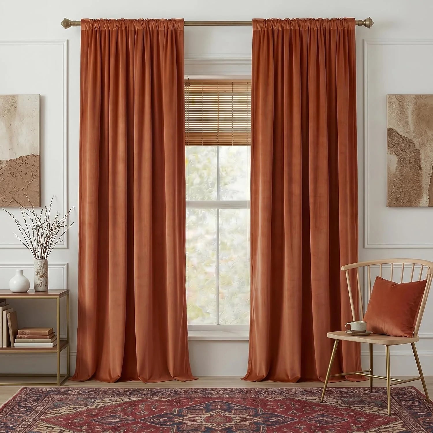 Rust velvet curtains framing a window with wood blinds in a warm modern living room