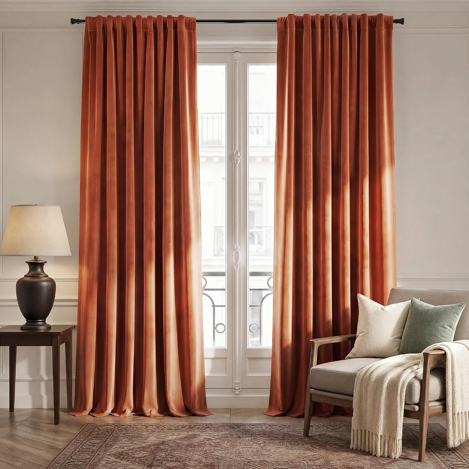 Rust velvet curtains framing a tall window in a warm neutral living room