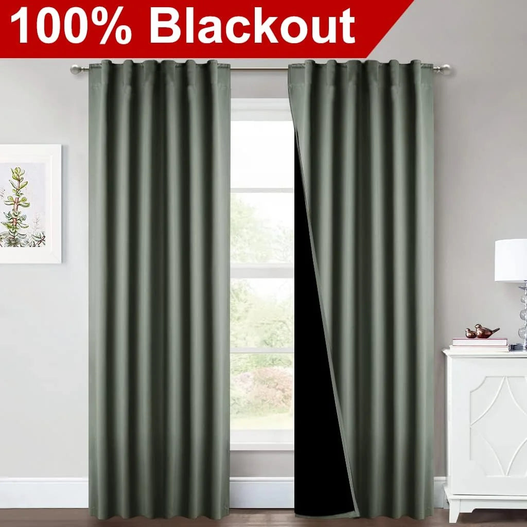 Sage green blackout curtain panels on a rod in a bright bedroom, one panel opened to show black lining