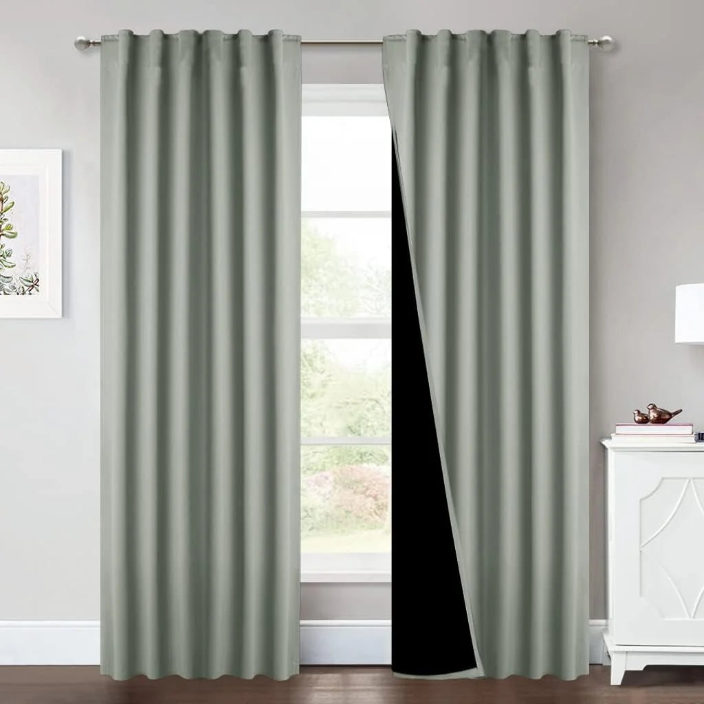 Sage green blackout curtains with rod pocket panels in a bright modern room