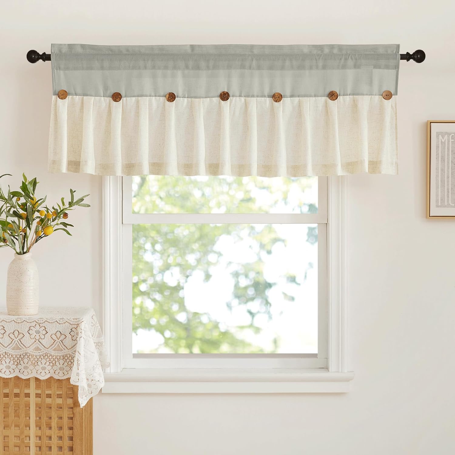 Cream and sage green two-tone valance with decorative wooden buttons hanging above a window.