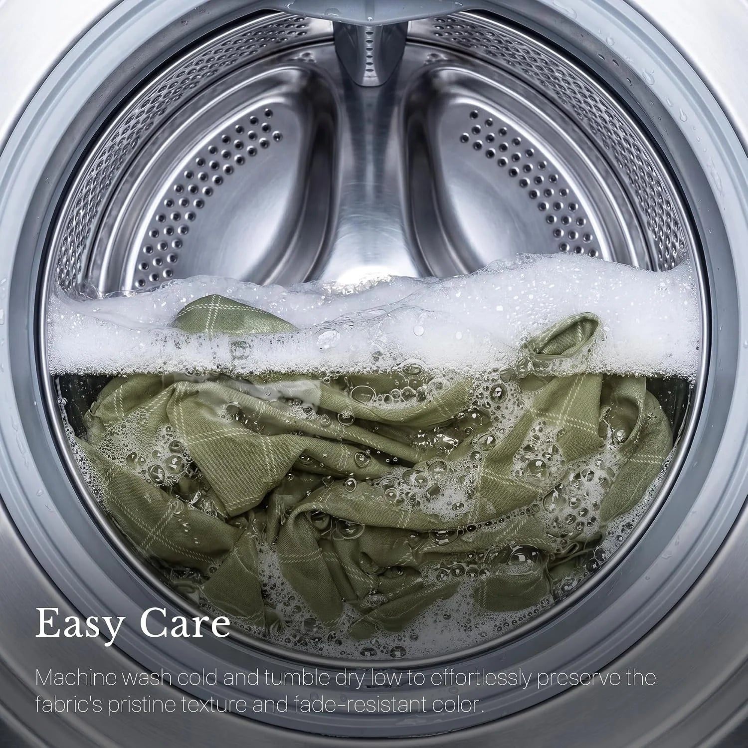 Sage green fabric being machine washed in a stainless steel front-load washer
