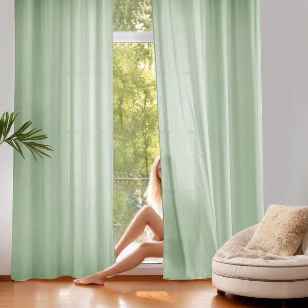 Elegant sage green room darkening curtains with grommet top hanging in a bright modern room.