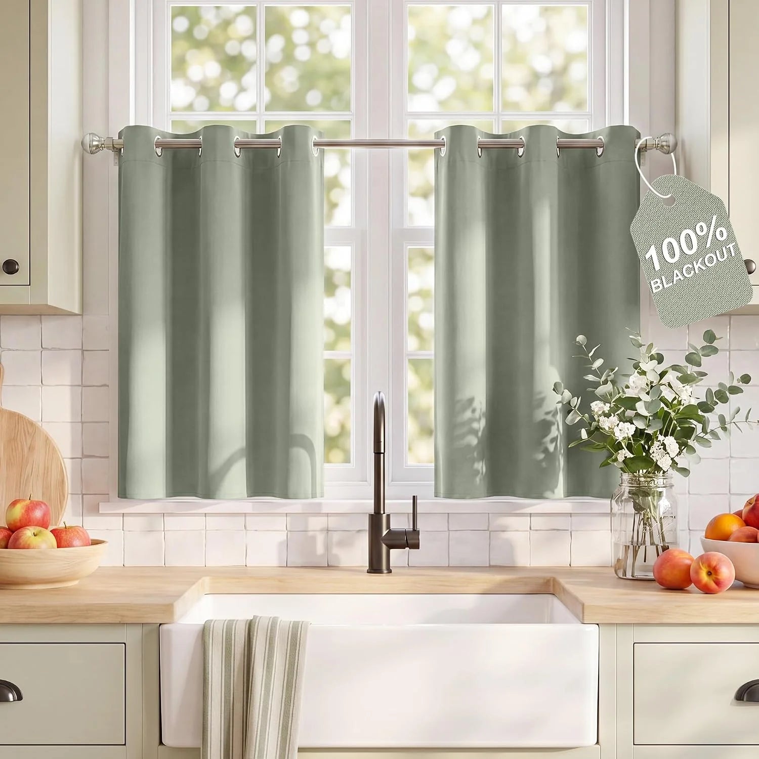 Sage green blackout grommet top cafe curtains on a kitchen window over a farmhouse sink with wood counters.