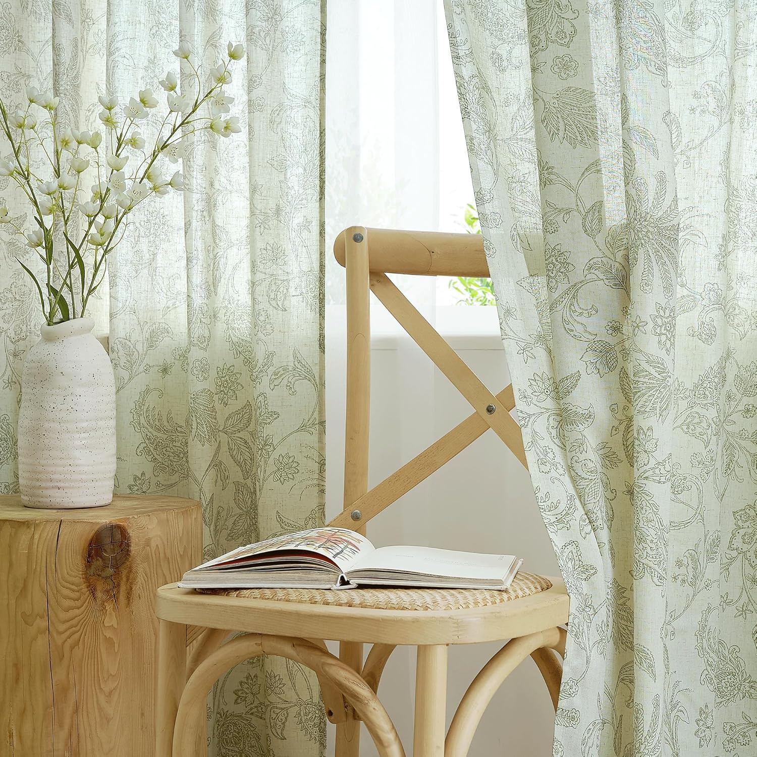 Light filtering linen-blend curtains with delicate sage green botanical pattern in a bright room.