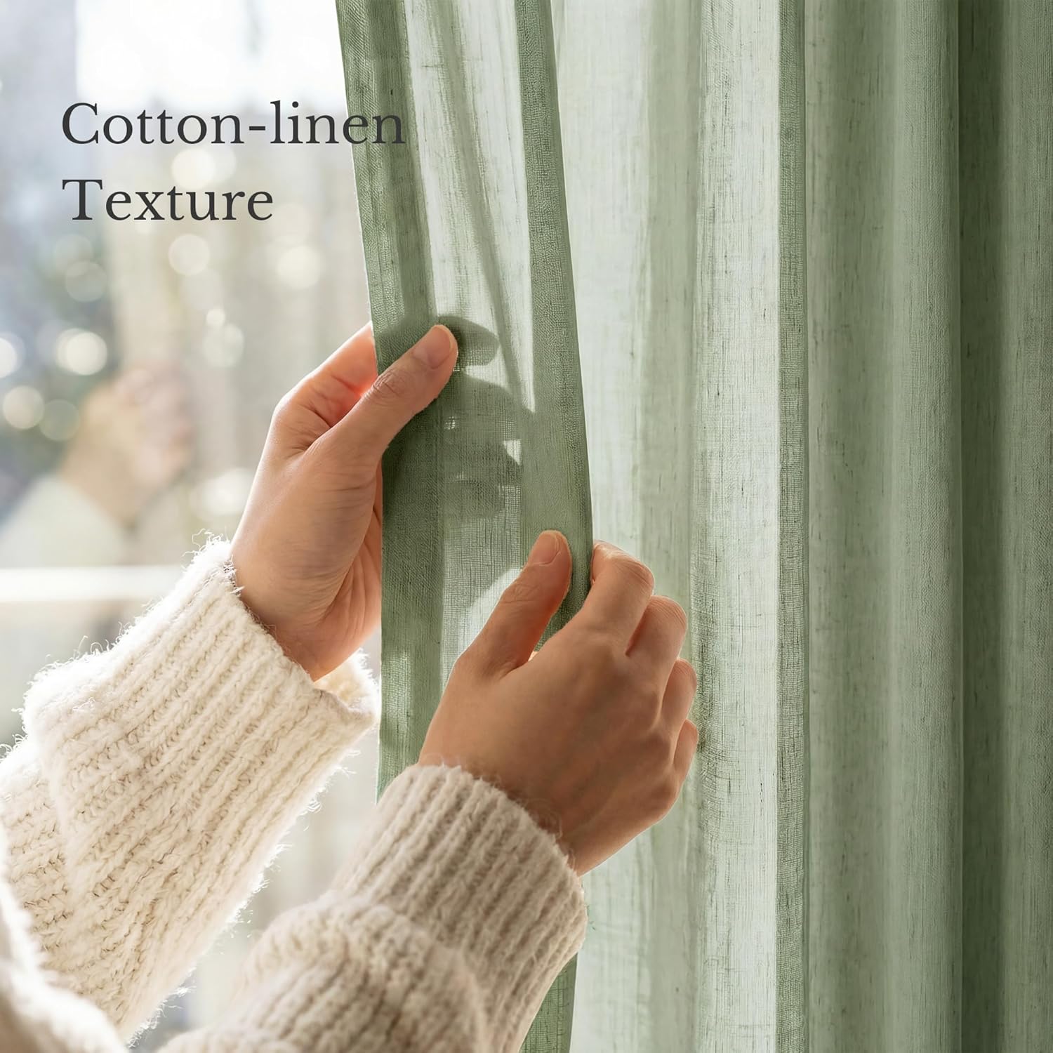 Hands touching a sage green cotton-linen sheer curtain, highlighting its natural texture and light filtering.