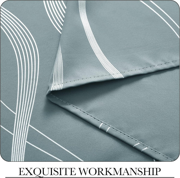 Sage green fabric close-up with white geometric curved lines and neat, detailed hem stitching.
