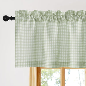 Sage green and white gingham check valance, gathered on black rod pocket over a wooden window.