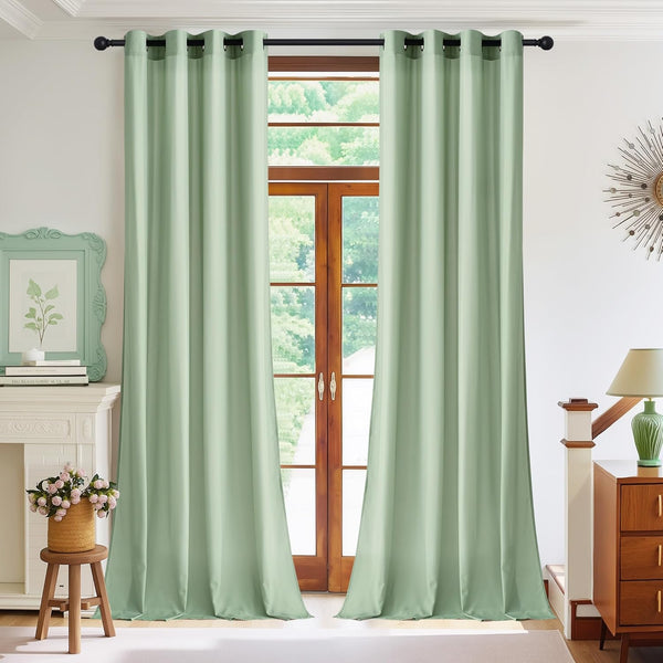 Pair of sage green blackout grommet top curtains on a black rod, framing a wooden door.