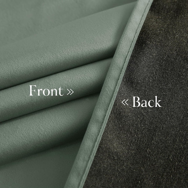 View of a sage green curtain fabric, highlighting its soft front and dark gray thermal lining back.