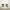 Two sage green linen look cafe curtains with rod pockets hanging above a kitchen sink window.