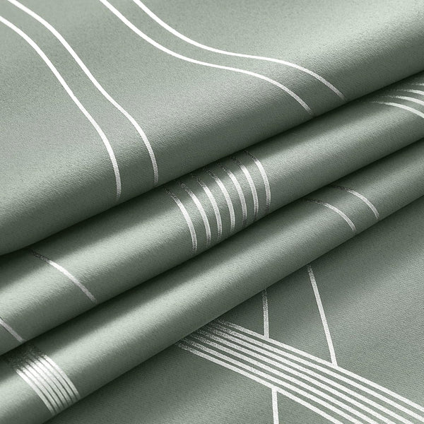 Detailed view of folded sage green fabric. Features silver metallic geometric lines and stripes on a textured surface.