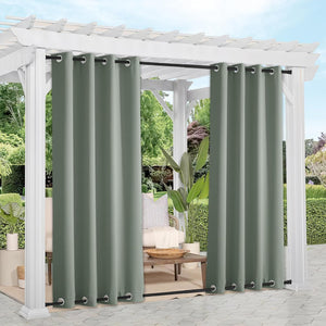 Sage green outdoor grommet curtains on black rods hang from a white pergola, providing patio privacy.