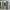 Solid sage green outdoor patio curtains with silver grommet tops hanging on a white pergola.