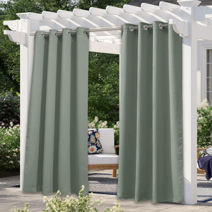 Solid sage green outdoor patio curtains with silver grommet tops hanging on a white pergola.