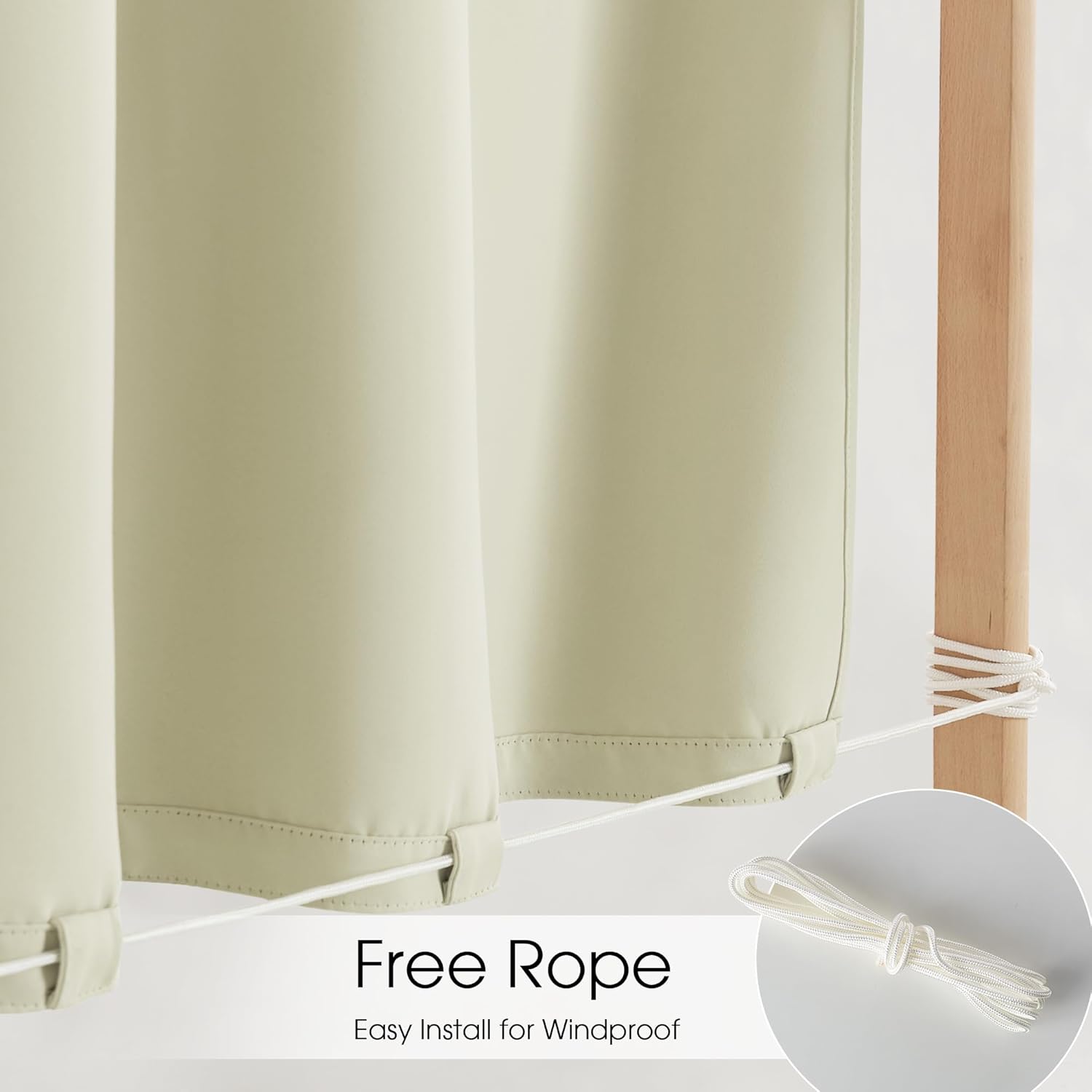 Sage green outdoor vertical shade panels show white rope tied to wood post for windproofing.