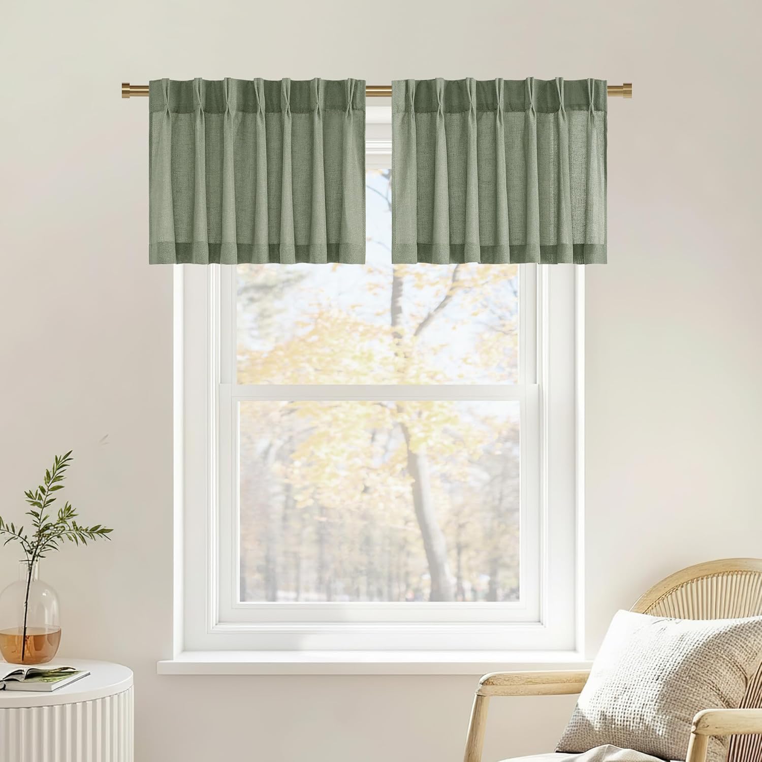 Sage green textured pinch pleat valance curtains on a gold rod above a bright window.