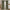 Sage green plaid rod pocket curtains with thin beige lines, hung on a black rod in a cozy room.