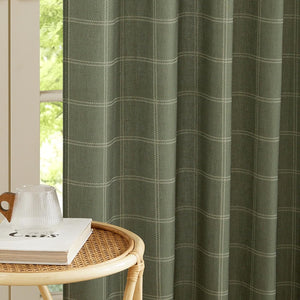 Textured sage green plaid window curtain with light dashed lines, gracefully pleated.