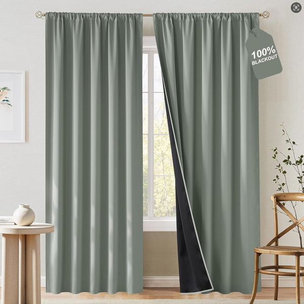 Sage green blackout curtains with a rod pocket top, showing the dark lining. Hung over a window.
