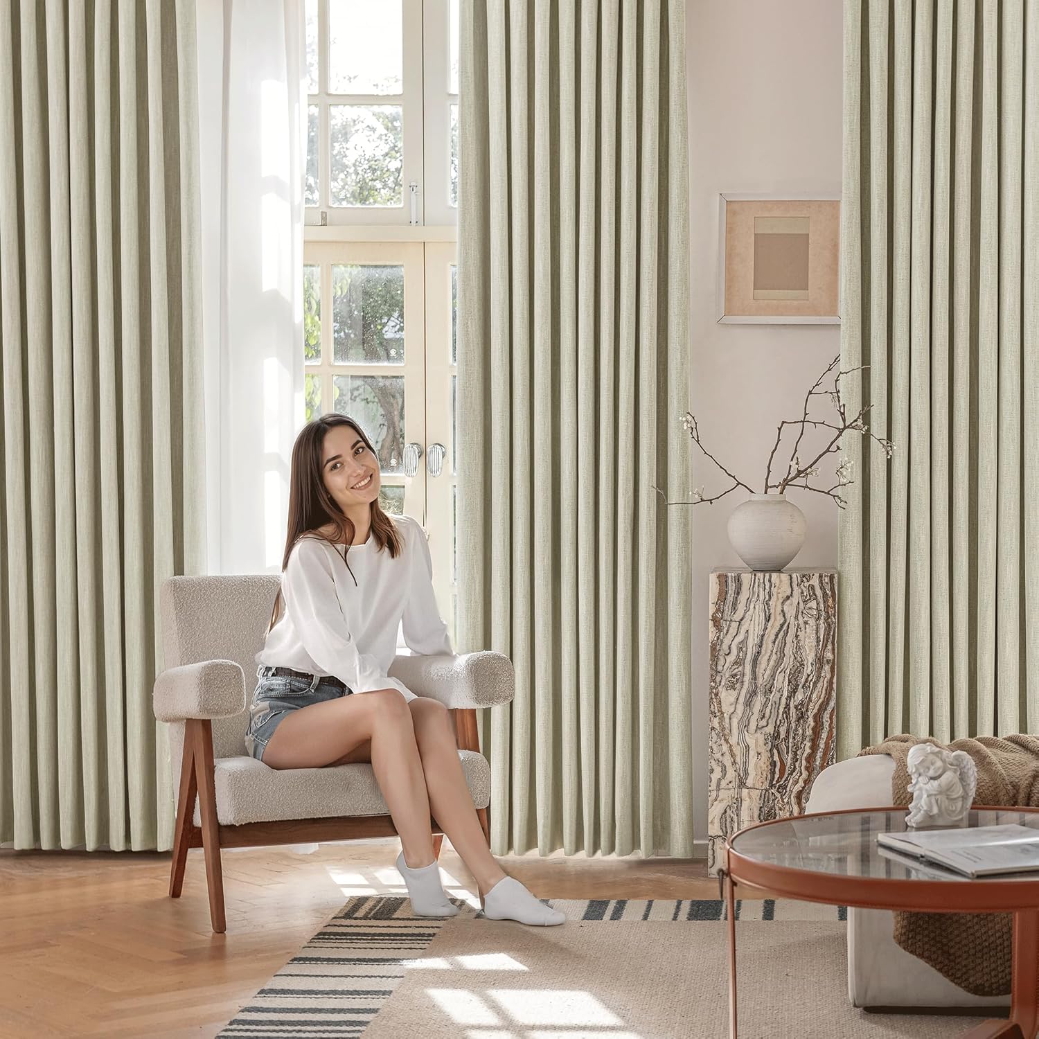 Sage green s-fold textured curtains frame a bright window in a modern living room setting.