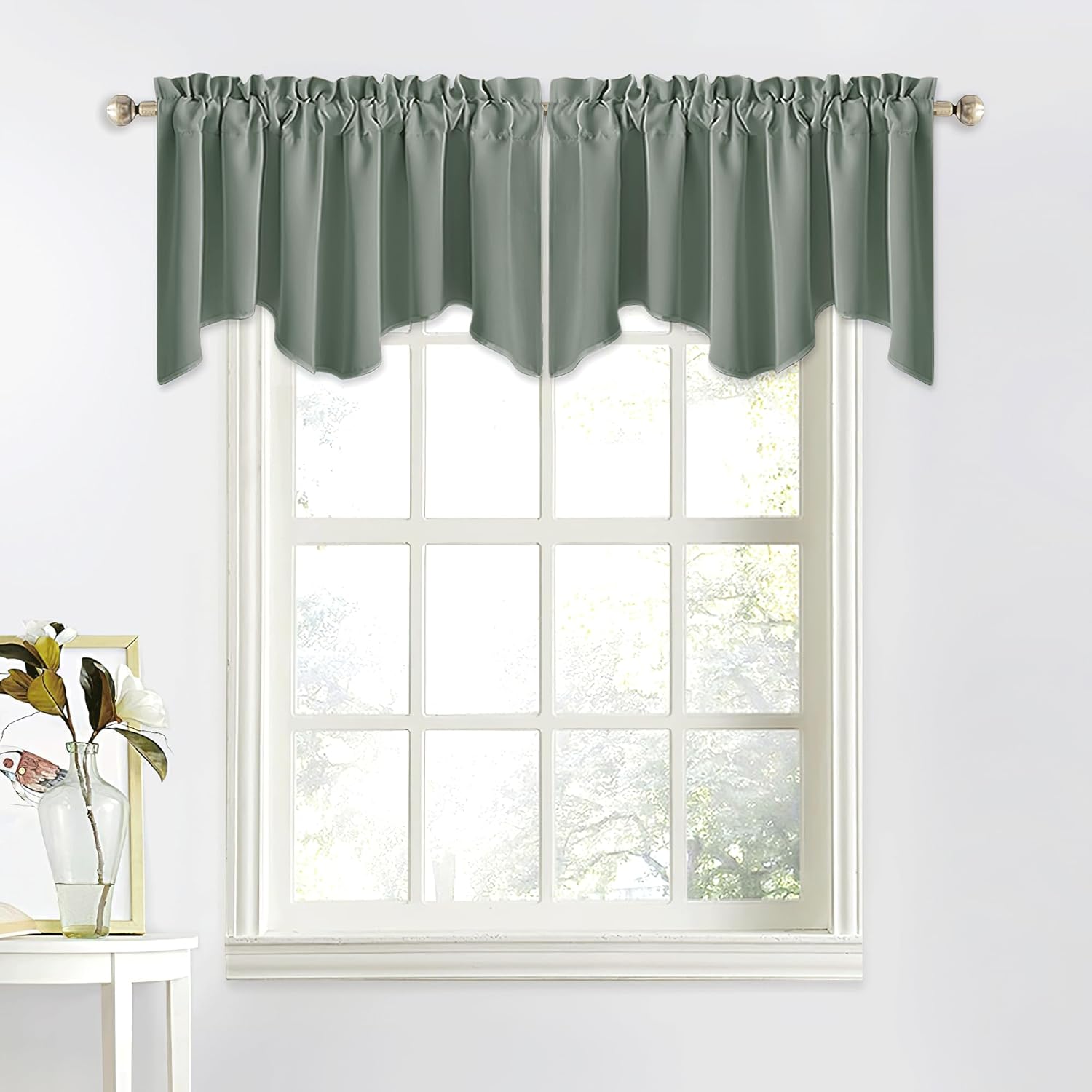 Sage green gathered valance with scalloped bottom edge on a gold curtain rod over a white window.