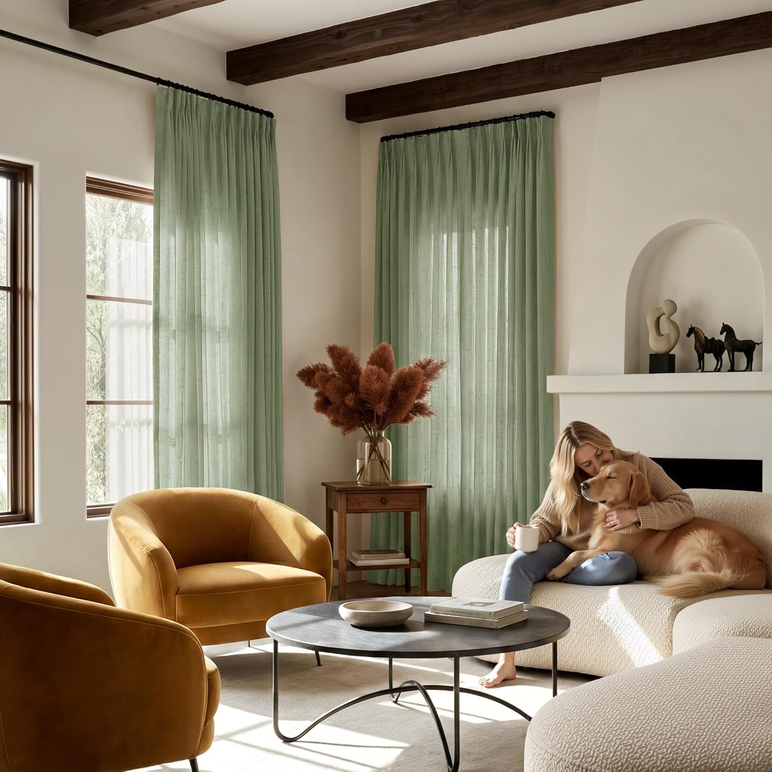 Sage green semi-sheer pinch pleat curtains with visible texture in a sunlit living room.