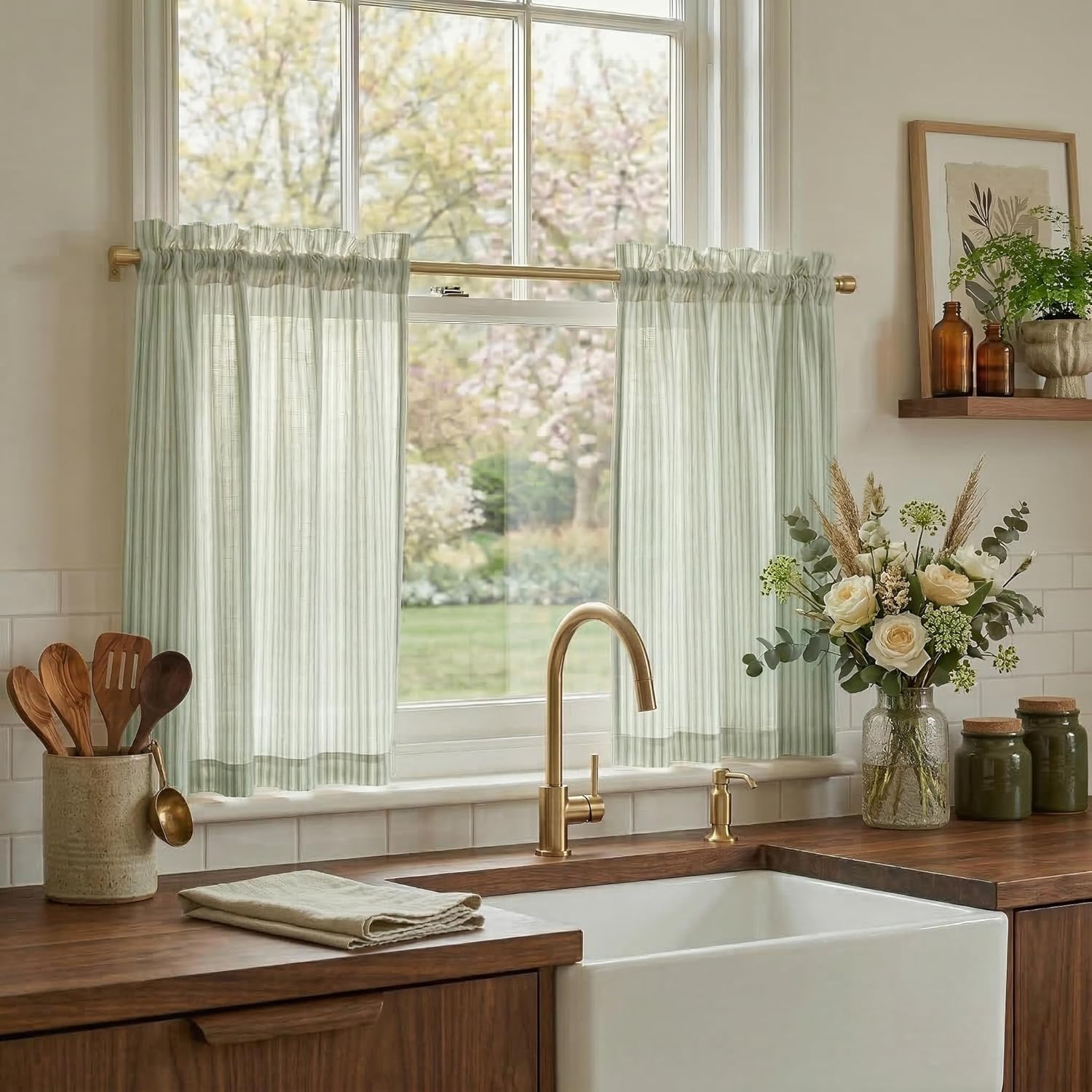 Light sage green striped cafe curtains with ruffled rod pocket top hanging in a sunlit farmhouse kitchen window.