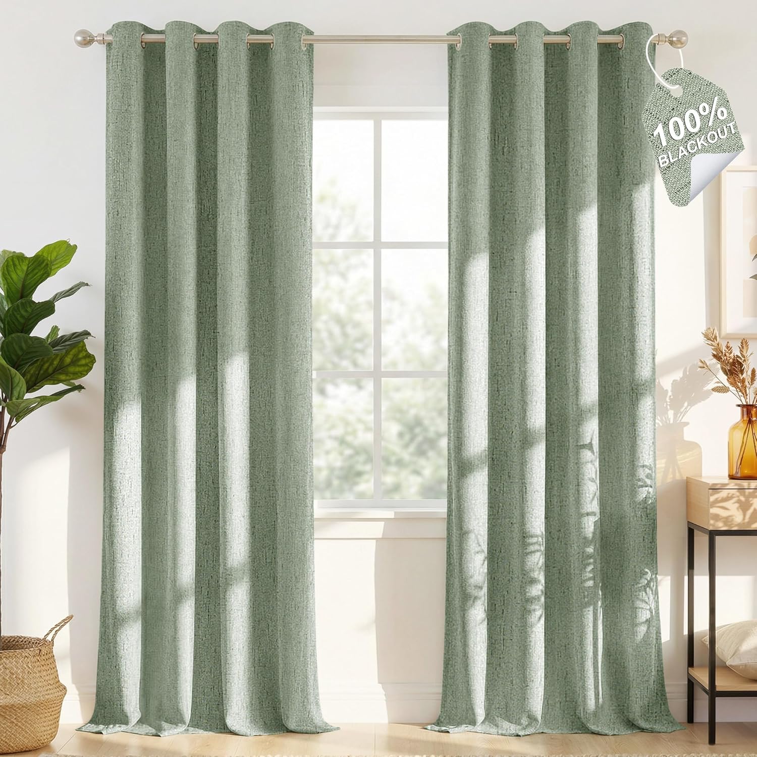 Sage green textured blackout curtains with grommet tops hang from a silver rod, fully covering a window.