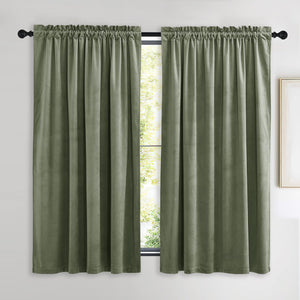 Two panels of sage green velvet rod pocket curtains with a gathered top, hanging on a black rod.