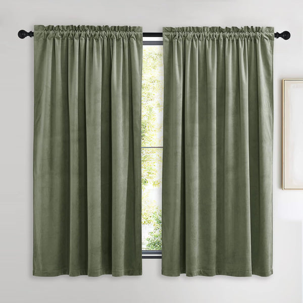 Two panels of sage green velvet rod pocket curtains with a gathered top, hanging on a black rod.